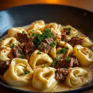Delicious cheesesteak tortellini in creamy provolone sauce served in a bowl