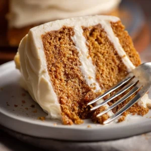 Delicious homemade spice cake topped with frosting and garnished with cinnamon.