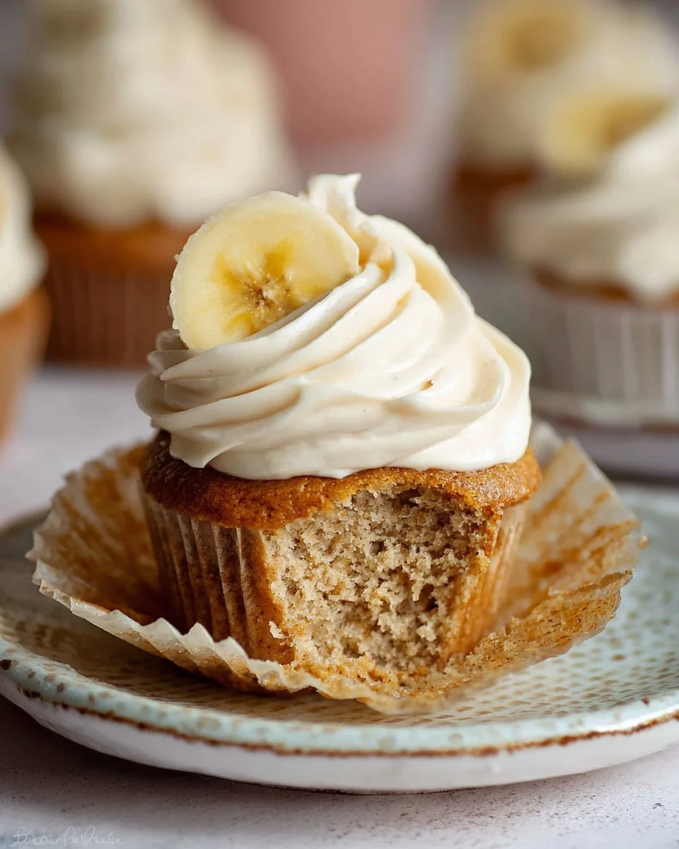 Delicious banana cupcakes with cinnamon cream cheese frosting on a plate
