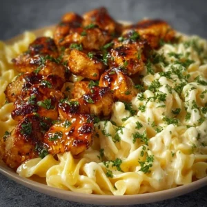 Delicious Lemon Garlic Butter Chicken with creamy parmesan pasta on a plate.